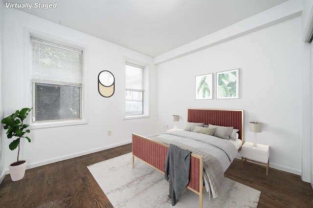 bedroom with baseboards and wood finished floors