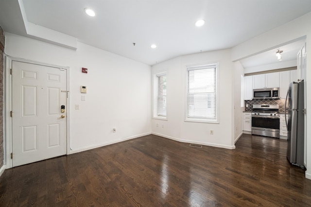 unfurnished living room featuring visible vents, baseboards, dark wood finished floors, and recessed lighting