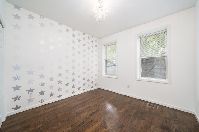 unfurnished room featuring wallpapered walls, baseboards, visible vents, and dark wood-style flooring