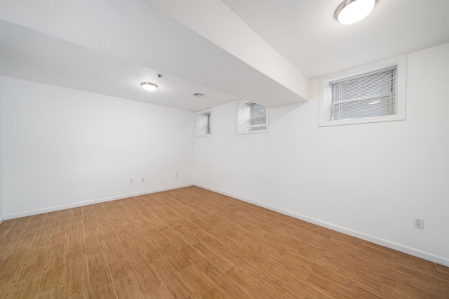 finished below grade area with light wood-type flooring and baseboards