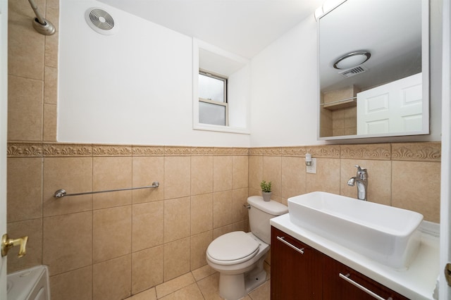 full bath with visible vents, toilet, tile patterned flooring, vanity, and tile walls