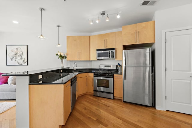83 Monroe St Unit 3A, Hoboken, NJ 07030 - kitchen with visible vents, a peninsula, light brown cabinets, and stainless steel appliances