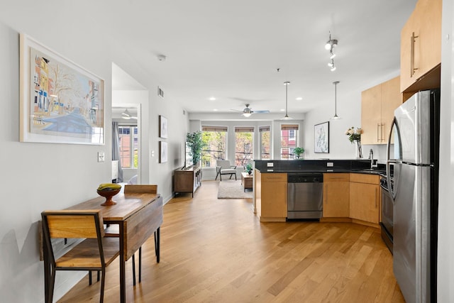 83 Monroe St Unit 3A, Hoboken, NJ 07030 - kitchen with ceiling fan, dark countertops, a peninsula, light wood-style floors, and stainless steel appliances