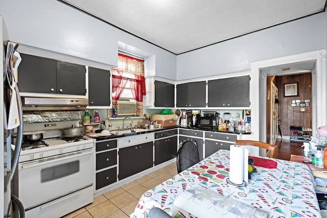 58 Booraem Ave, Jersey City, NJ 07307 - kitchen with gas range gas stove, under cabinet range hood, dark countertops, light tile patterned floors, and a sink