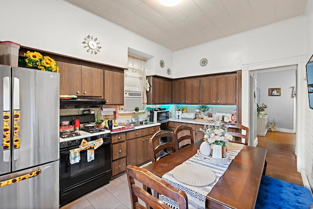 58 Booraem Ave, Jersey City, NJ 07307 - kitchen featuring black appliances, crown molding, backsplash, range hood, and light countertops