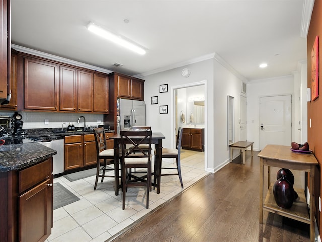 5808 Washington St Unit 406A, West New York, NJ 07093 - kitchen with stainless steel appliances, backsplash, ornamental molding, light wood-style flooring, and dark stone counters