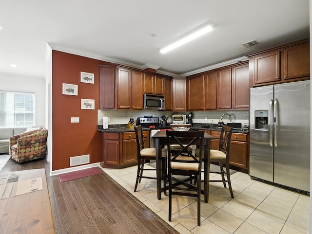 5808 Washington St Unit 406A, West New York, NJ 07093 - kitchen featuring stainless steel appliances, backsplash, ornamental molding, and light wood-style flooring