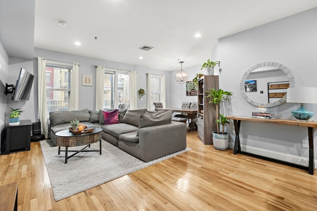 living room featuring visible vents, a notable chandelier, recessed lighting, wood-type flooring, and baseboards