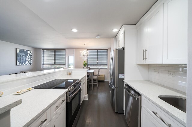 kitchen with stainless steel appliances, pendant lighting, a kitchen bar, sink, and white cabinetry