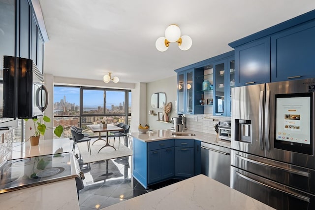 380 Mountain Rd Unit 1012, Union City, NJ 07087 - kitchen with stainless steel appliances, blue cabinets, a chandelier, and backsplash