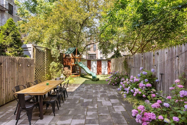 908 Garden St Unit 1, Hoboken, NJ 07030 - fenced backyard with a patio, a playground, and outdoor dining space
