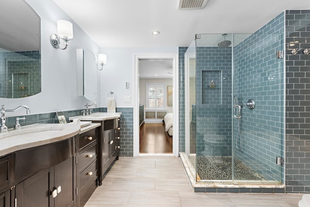 908 Garden St Unit 1, Hoboken, NJ 07030 - ensuite bathroom featuring a stall shower, tile walls, two vanities, tile patterned flooring, and recessed lighting