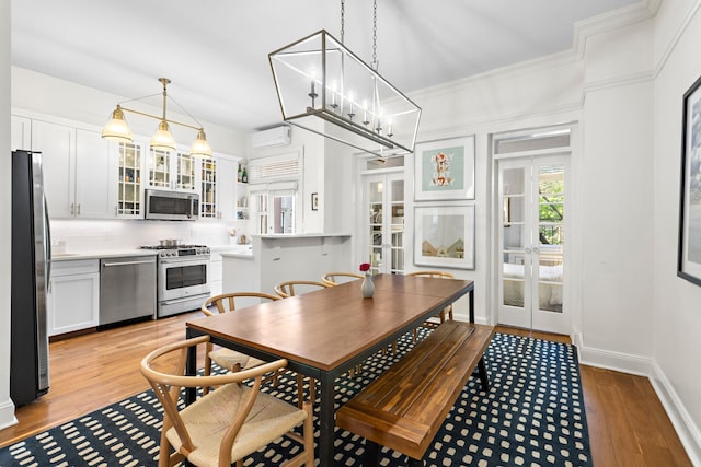 908 Garden St Unit 1, Hoboken, NJ 07030 - dining room featuring a wall mounted AC, light wood-type flooring, french doors, and crown molding