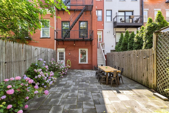 908 Garden St Unit 1, Hoboken, NJ 07030 - rear view of property featuring brick siding, outdoor dining area, stairway, and a patio
