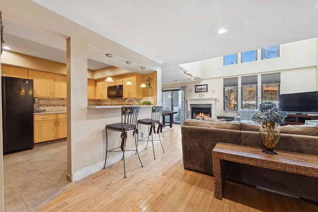 living room with track lighting, ornamental molding, and light hardwood / wood-style flooring