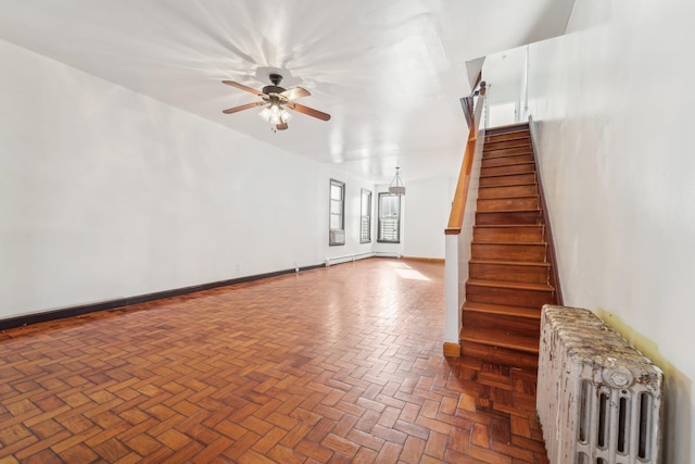 unfurnished living room featuring parquet floors, radiator heating unit, and ceiling fan