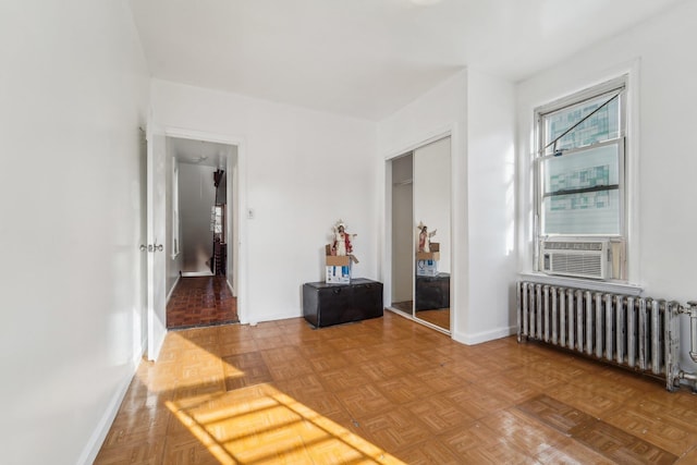 corridor featuring parquet flooring, radiator heating unit, and cooling unit