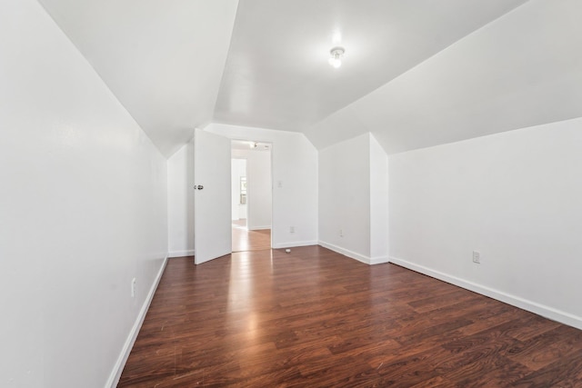 bonus room with vaulted ceiling and dark wood-type flooring