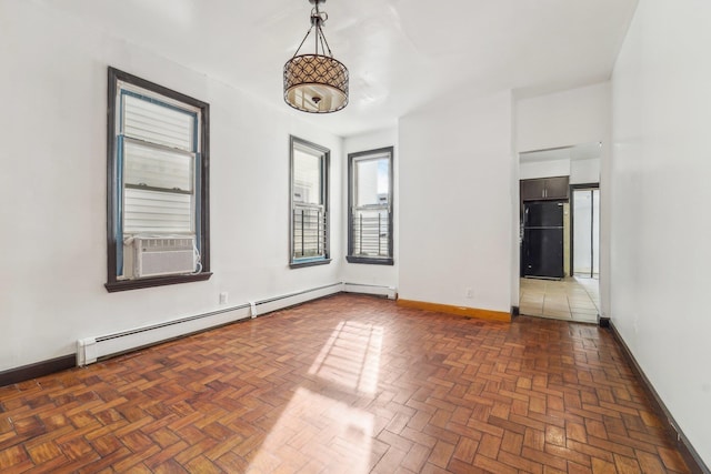 spare room featuring cooling unit, dark parquet flooring, and a baseboard radiator