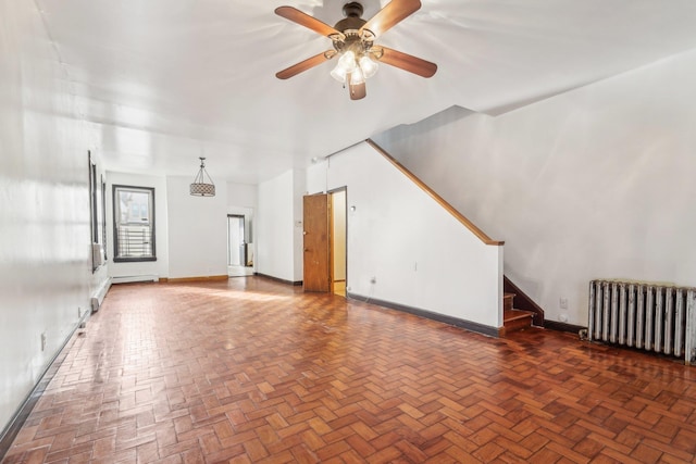 unfurnished living room featuring radiator and ceiling fan