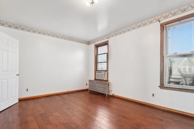 empty room featuring dark hardwood / wood-style flooring, radiator heating unit, and cooling unit