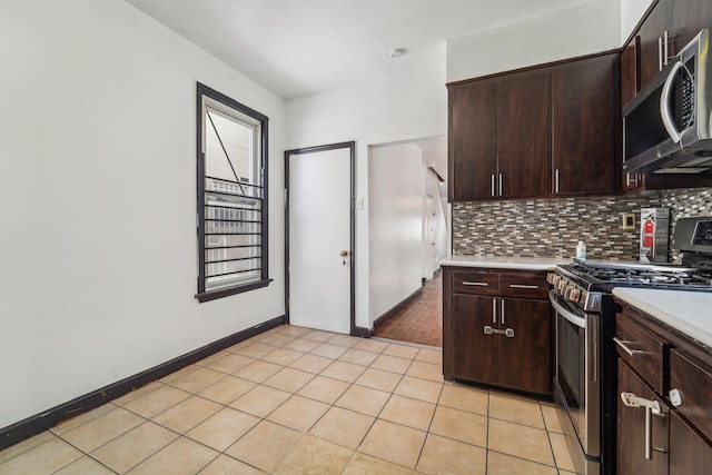 kitchen featuring appliances with stainless steel finishes, dark brown cabinetry, and backsplash