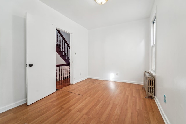 empty room with radiator and light hardwood / wood-style flooring