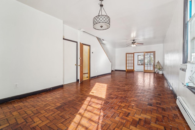 unfurnished living room featuring dark parquet floors, a baseboard radiator, and ceiling fan