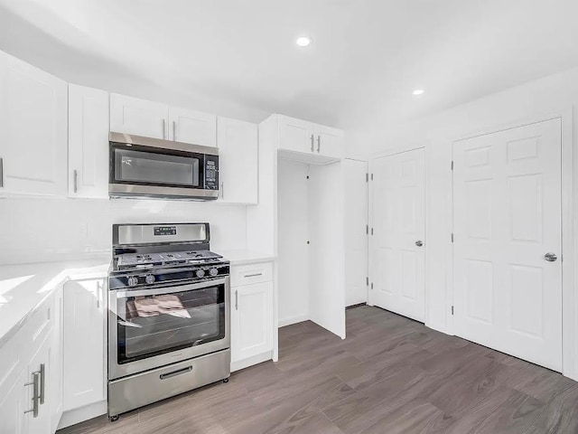 21 Freedom Pl, Jersey City, NJ 07065 - kitchen with stainless steel appliances, white cabinets, light countertops, dark wood finished floors, and recessed lighting