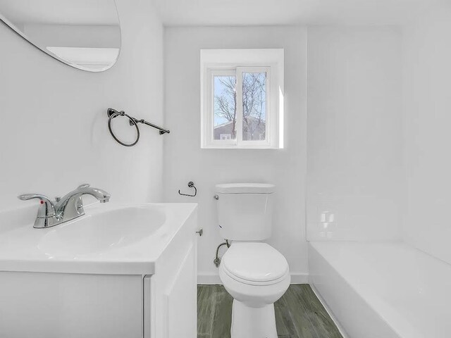 21 Freedom Pl, Jersey City, NJ 07065 - bathroom with vanity, toilet, baseboards, and wood finished floors