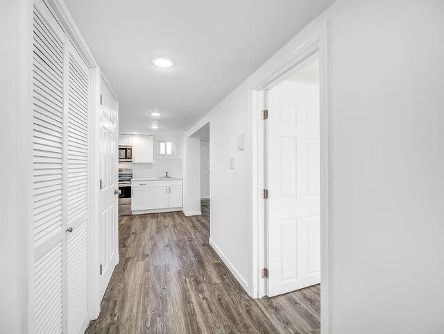 21 Freedom Pl, Jersey City, NJ 07065 - corridor featuring dark wood-type flooring, a sink, and baseboards