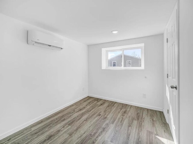 21 Freedom Pl, Jersey City, NJ 07065 - unfurnished room with a wall mounted air conditioner, wood finished floors, baseboards, and recessed lighting