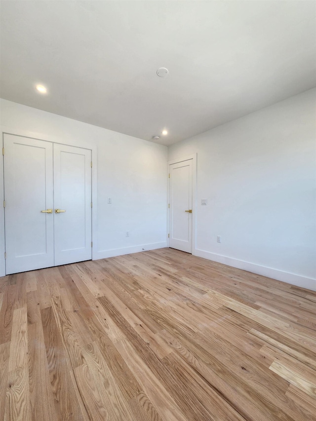 unfurnished bedroom featuring light hardwood / wood-style floors and a closet