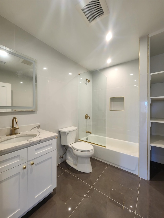 full bathroom featuring toilet, vanity, tiled shower / bath, and tile patterned flooring