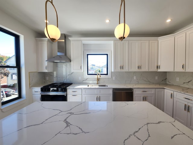 kitchen with dishwashing machine, wall chimney exhaust hood, range with gas stovetop, decorative light fixtures, and sink