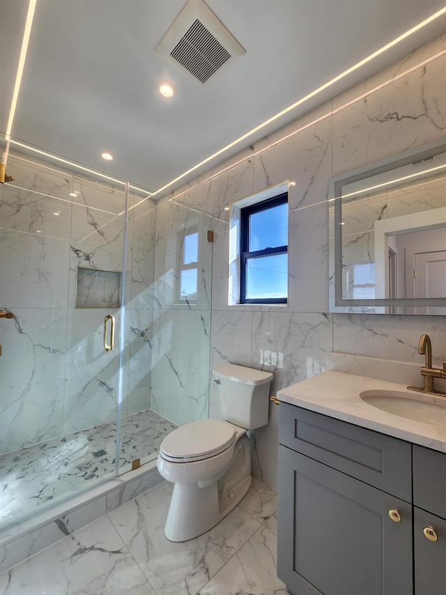 bathroom with toilet, tile walls, a shower with shower door, and vanity