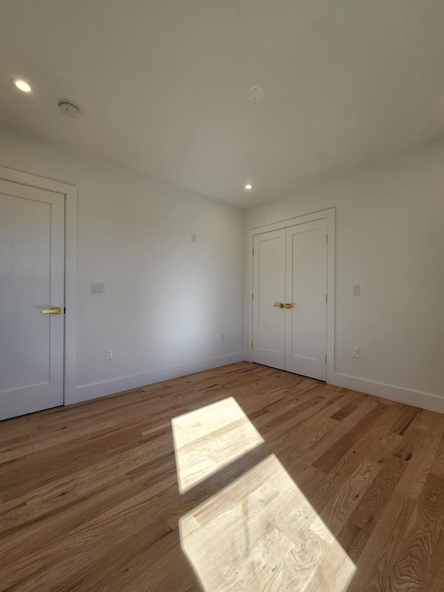 unfurnished bedroom featuring a closet and light hardwood / wood-style floors