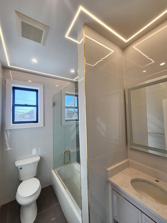 full bathroom with toilet, enclosed tub / shower combo, tile patterned flooring, and vanity