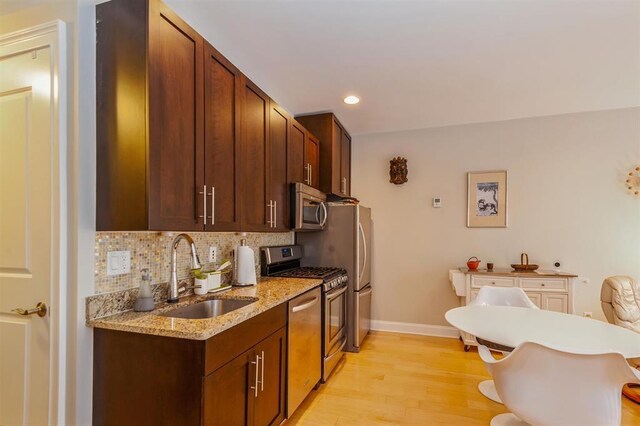 112 Liberty View Dr Unit 2A, Jersey City, NJ 07302 - kitchen with stainless steel appliances, tasteful backsplash, light wood-type flooring, a breakfast bar area, and recessed lighting