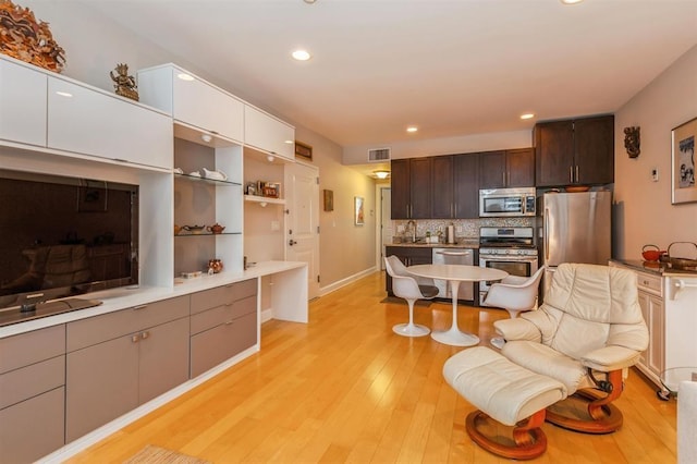 112 Liberty View Dr Unit 2A, Jersey City, NJ 07302 - kitchen featuring stainless steel appliances, dark brown cabinets, light wood-style flooring, backsplash, and recessed lighting