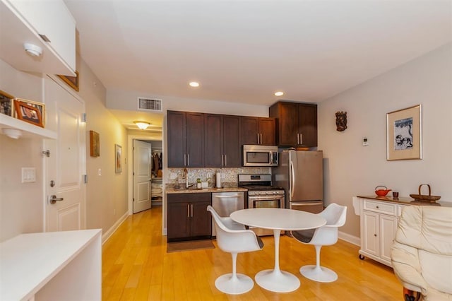 112 Liberty View Dr Unit 2A, Jersey City, NJ 07302 - kitchen featuring stainless steel appliances, dark brown cabinets, backsplash, light wood-style floors, and recessed lighting