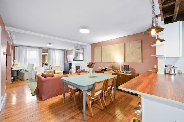 233 Summit Ave, Jersey City, NJ 07304 - dining room with a fireplace, light wood-style floors, and ornamental molding