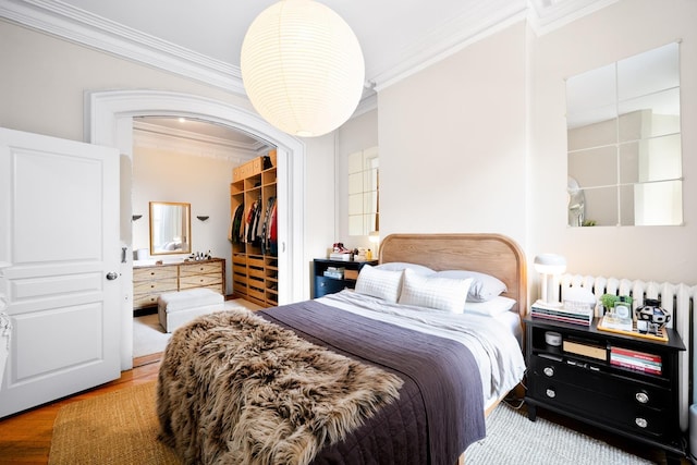 233 Summit Ave, Jersey City, NJ 07304 - bedroom featuring ornamental molding, a walk in closet, a closet, and wood finished floors