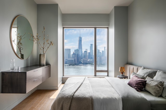 99 Hudson St Unit 3708, Jersey City, NJ 07302 - bedroom featuring a city view, baseboards, and light wood-style flooring