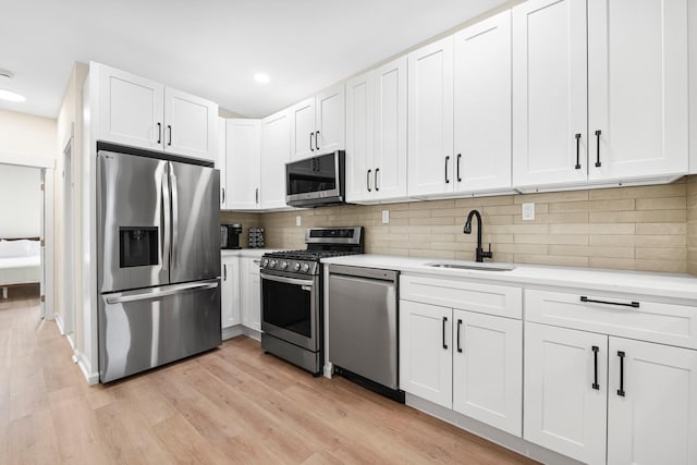366 7th St Unit 2, Jersey City, NJ 07302 - kitchen featuring stainless steel appliances, light countertops, light wood-style floors, white cabinets, and recessed lighting