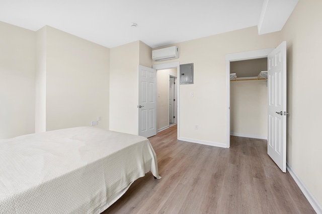 366 7th St Unit 2, Jersey City, NJ 07302 - bedroom with a wall mounted air conditioner, light wood-type flooring, a closet, a walk in closet, and electric panel