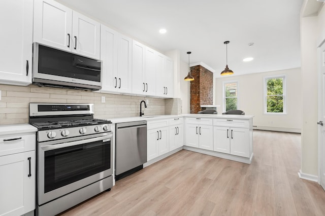 366 7th St Unit 2, Jersey City, NJ 07302 - kitchen featuring stainless steel appliances, a baseboard heating unit, light countertops, light wood-type flooring, and white cabinets