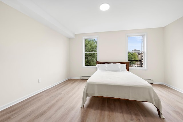 366 7th St Unit 2, Jersey City, NJ 07302 - bedroom featuring light wood-style flooring, multiple windows, and a baseboard radiator
