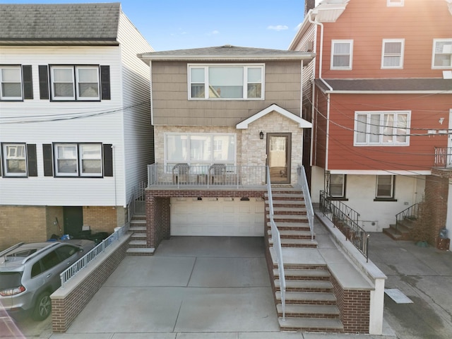 view of property featuring stairs, stone siding, a garage, and driveway