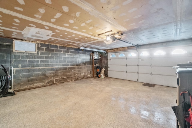 garage featuring a garage door opener and concrete block wall